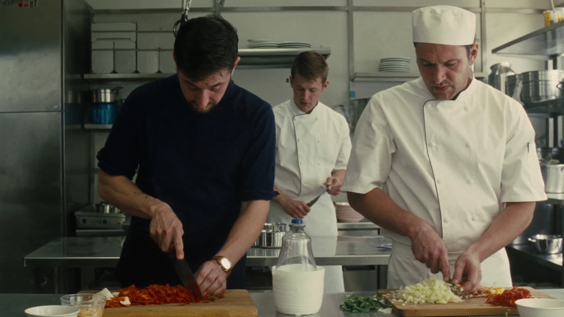 Brigade qui taille des légumes dans une cuisine de restaurant